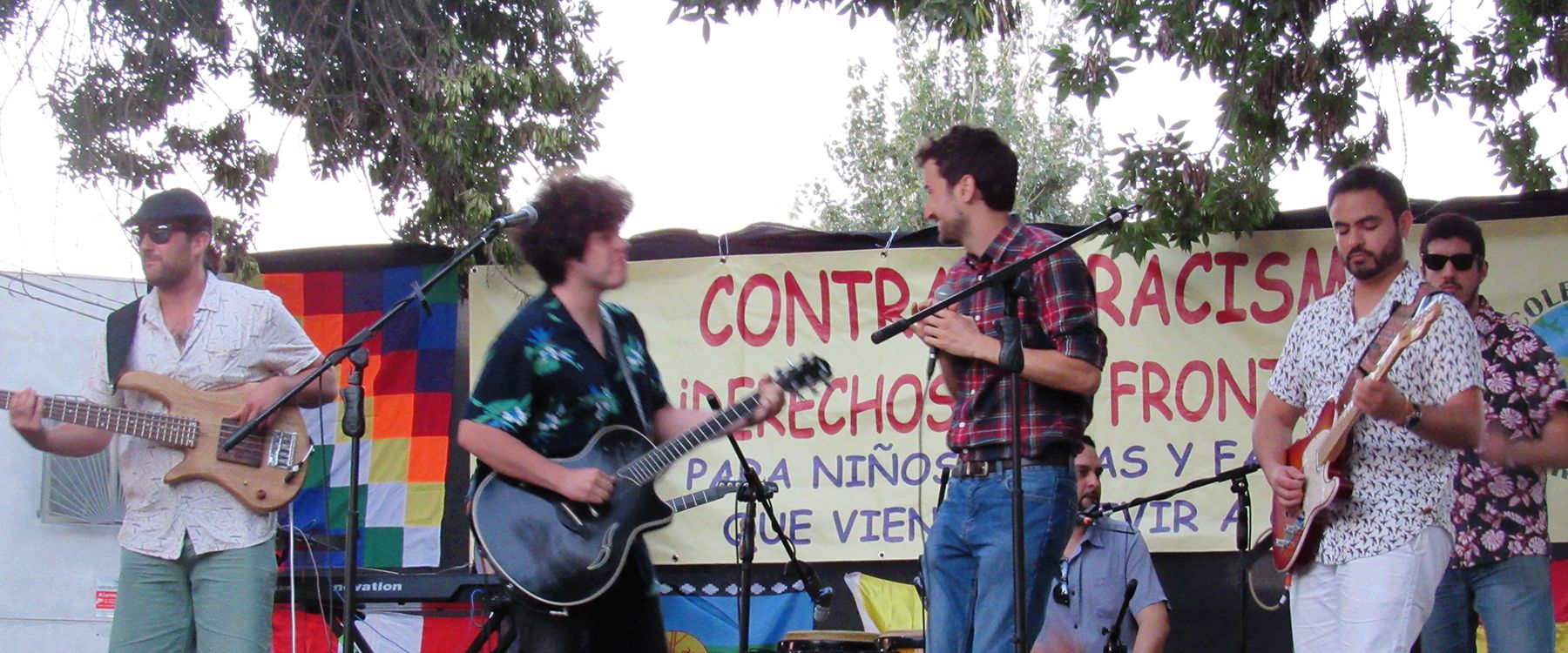 Una banda toca frente a un lienzo que dice Contra el racismo, derechos sin fronteras