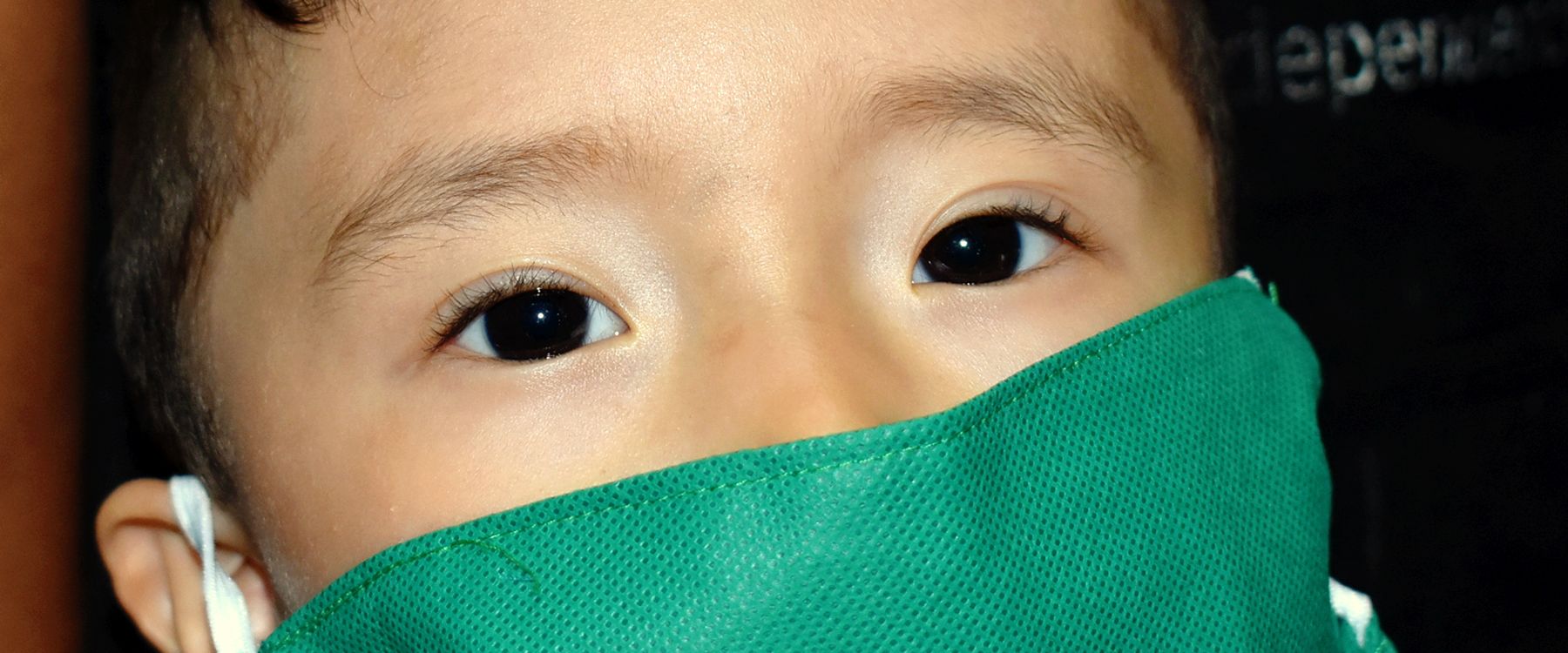 Primer plano de un niño con mascarilla verde
